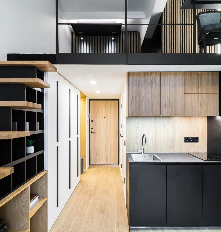 Mieszkanie z drewnianymi elementami oraz czarnymi szafkami w kuchni